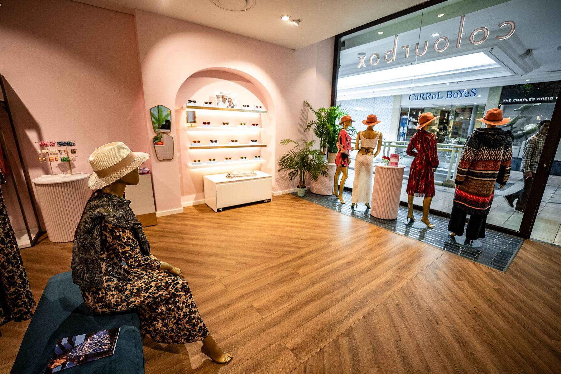 Gold mannequins styled through a modern Colour Box store interior