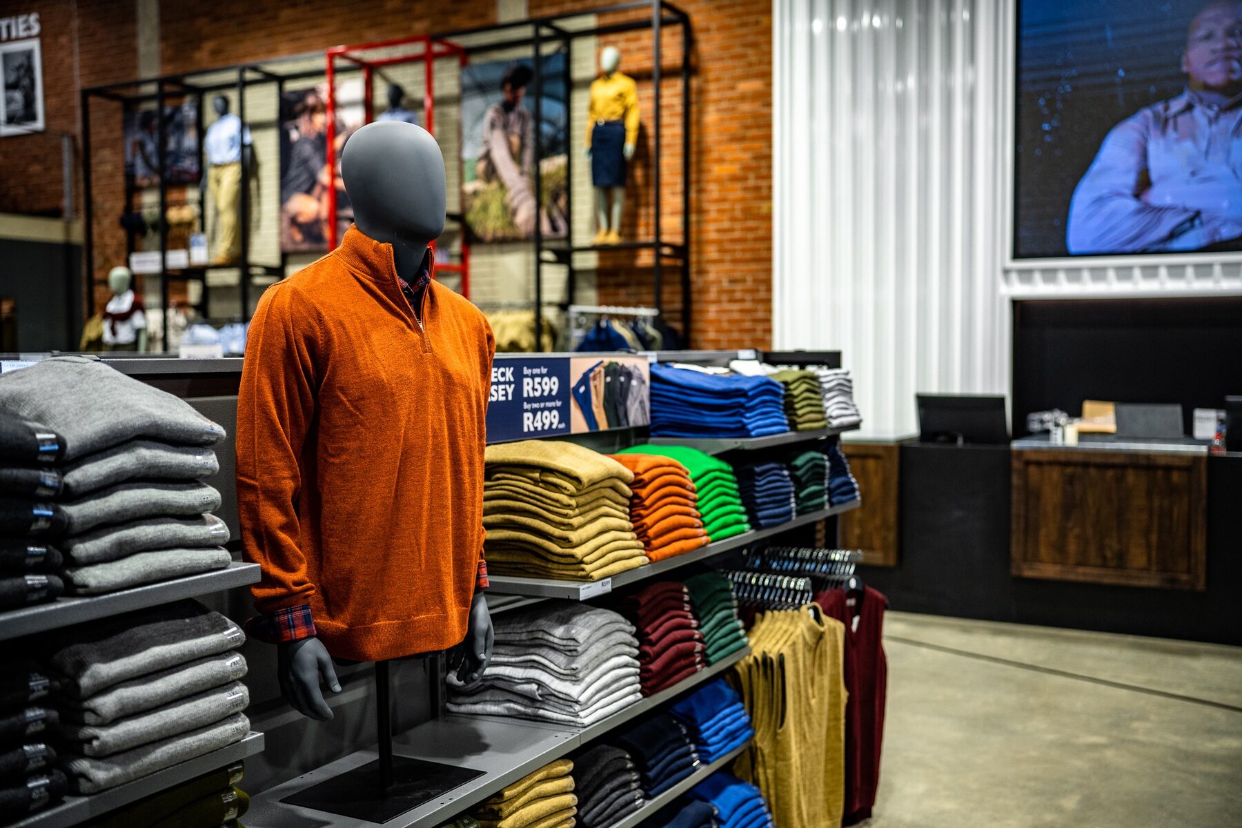 A torso mannequin presenting orange knitwear in store