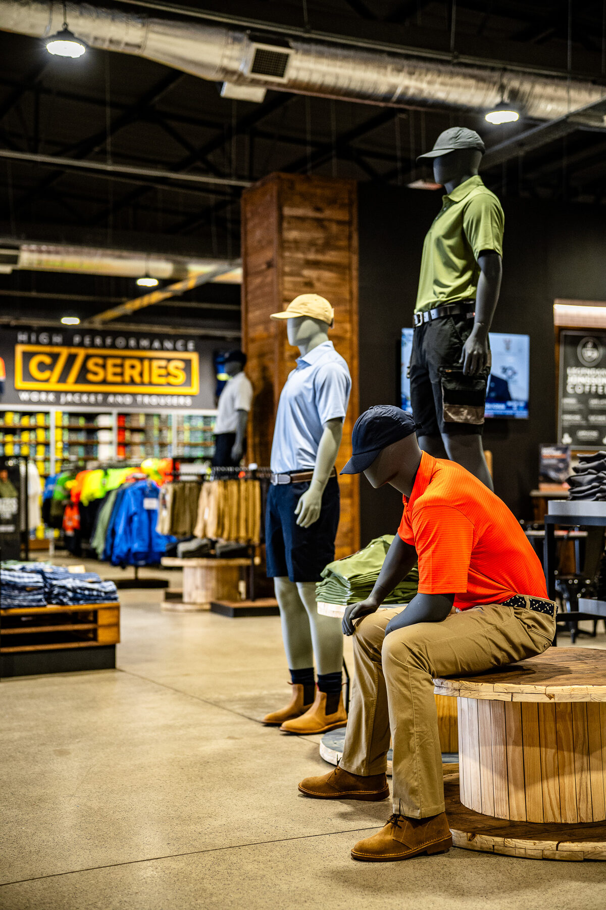 Standing and seated male mannequins presenting a workwear collection