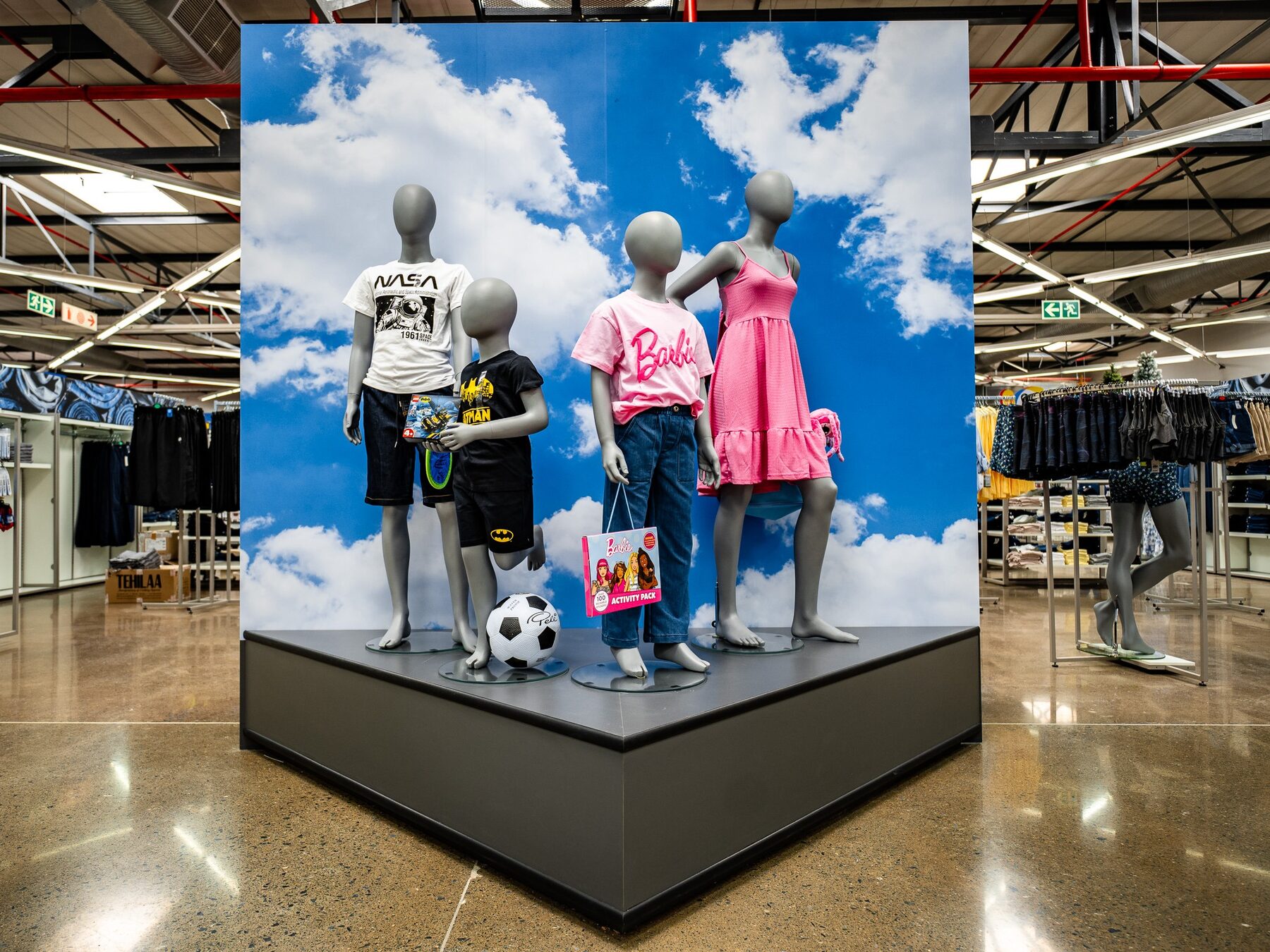 A family of children and youth mannequins presenting a colourful retail collection
